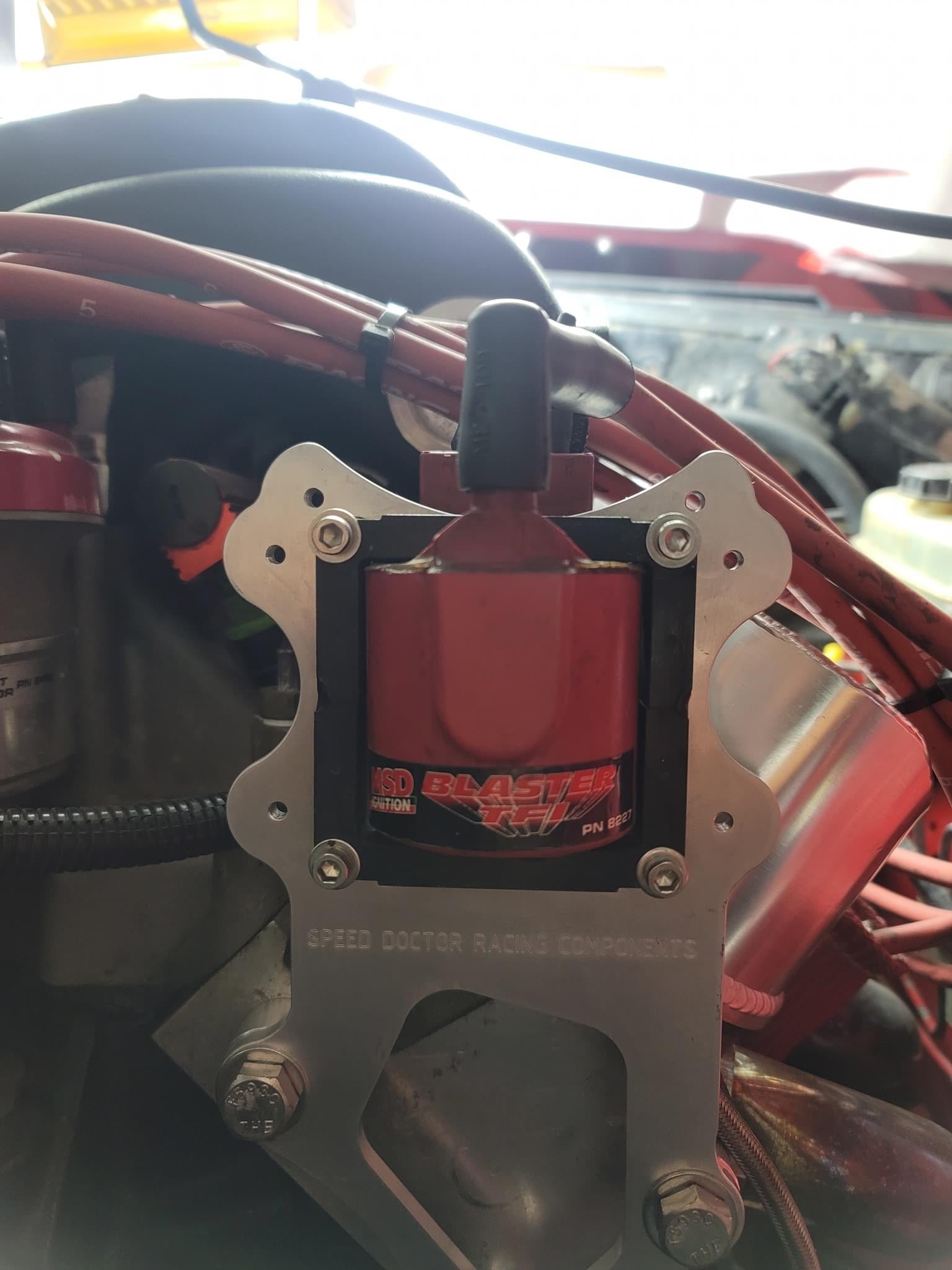 Universal ignition coil bracket mounted on engine